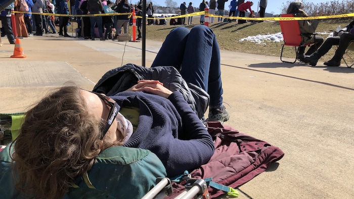 Woman lying on the ground looking at the sky while wearing goggles. 
