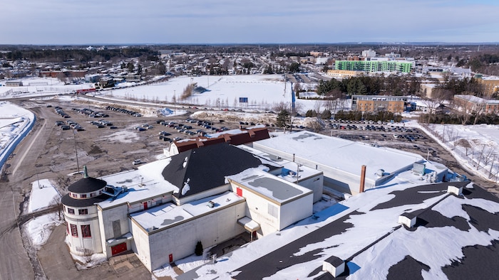 Des bâtiments et un stationnement en hiver.
