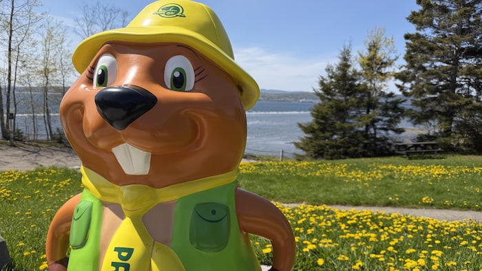 Une statue de la mascotte de Parcs Canada. C'est un castor portant un chapeau, un foulard et une petite veste.