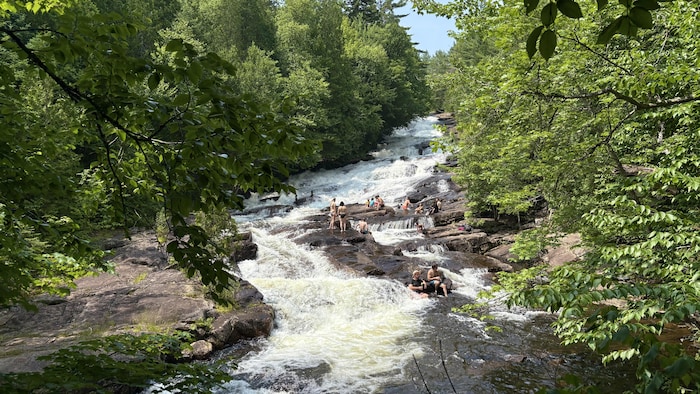 Des personnes se baignent dans une rivière dans le parc national de la Mauricie.