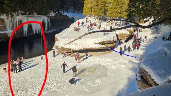 Plusieurs personnes sont sur le bord d'une rivière dégelée.