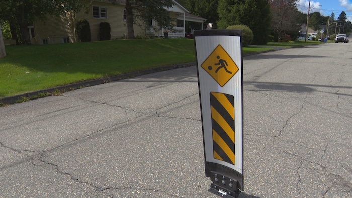 Un panneau au milieu de la chaussée de la rue Beaudoin. 
