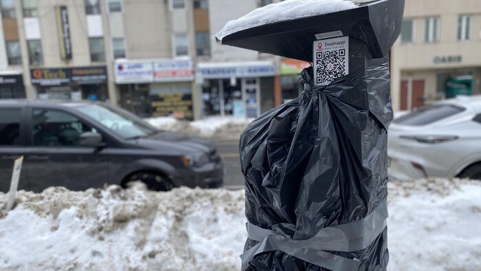 Un sac de poubelles enroulé autour d'un parcomètre sur l'avenue Danforth à Toronto, le 23 février 2025.