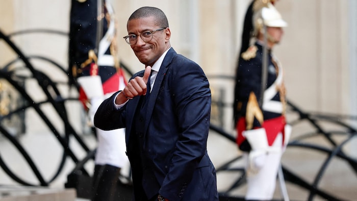 Karim Bouamrane, pouce en l'air, devant un homme qui monte la garde.