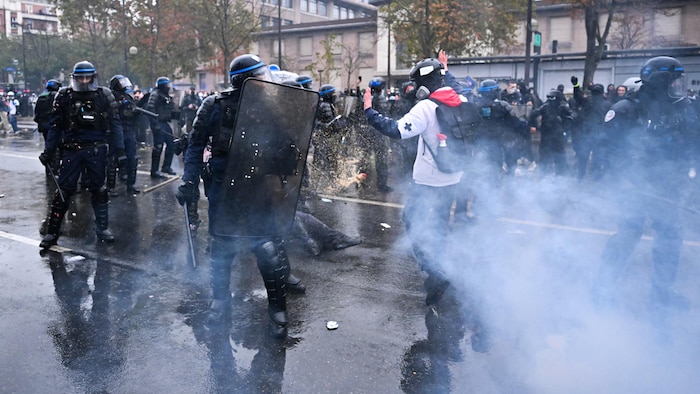 Un secouriste cherche à se faufiler entre les policiers près de la porte de Vincennes lors d’une manifestation.