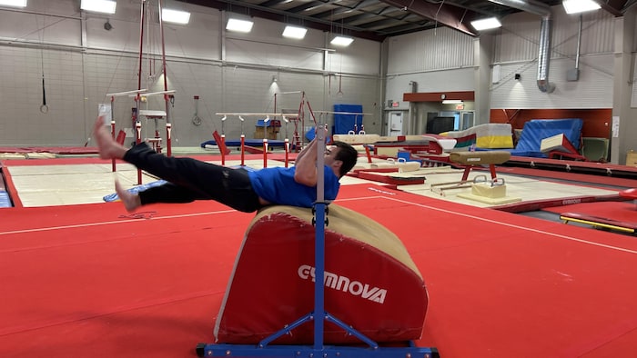 Un homme fait du parkour dans un gymnase.