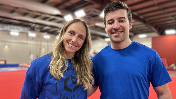 Un homme et une femme posent dans un gymnase.
