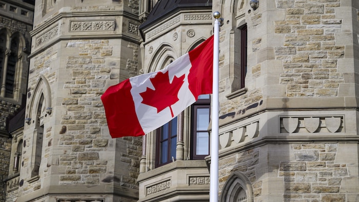 Un drapeau devant le parlement du Canada.