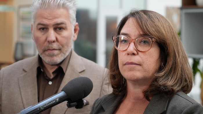 Marie-Claude Sarrazin se tient devant un microphone, aux côtés de Pascal Bérubé au second plan.