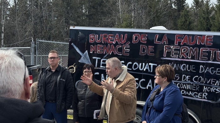 Quatre personnes se tiennent debout face à une foule, et le député Pascal Bérubé parle avec ses mains.