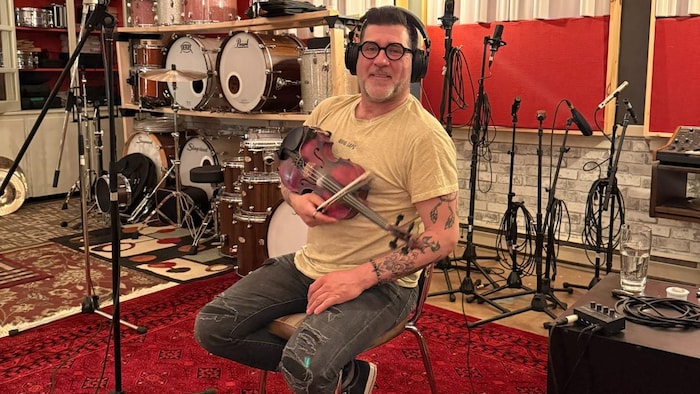 Pascal Miousse en studio avec un violon.