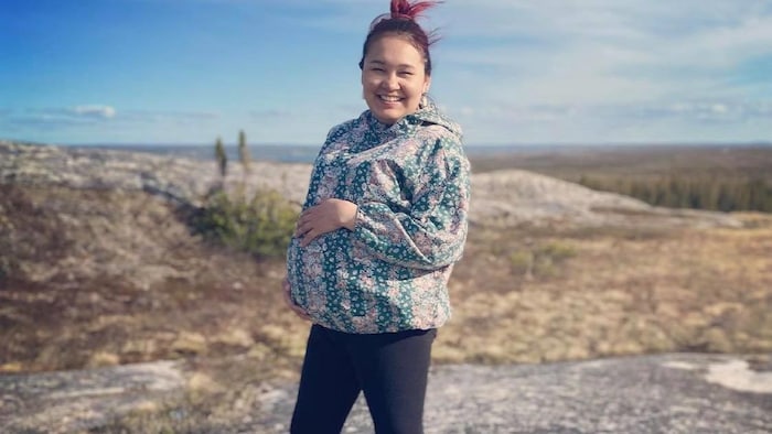 La femme enceinte pose dans la toundra du Nunavik.