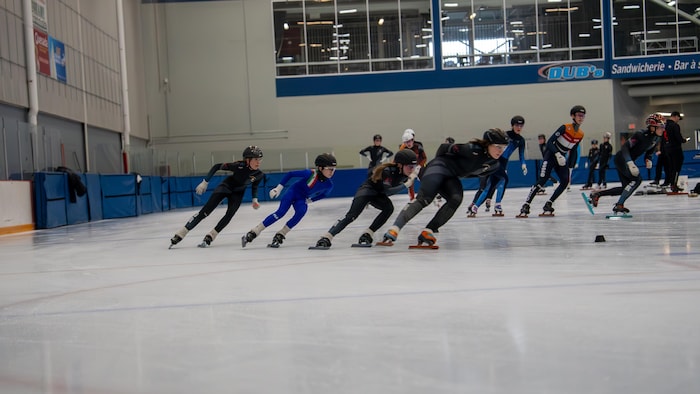 Des patineurs de vitesse adolescents sont sur une glace.