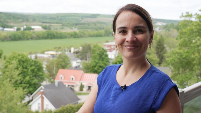 Une femme habillée en bleu sur un balcon à l'extérieur.