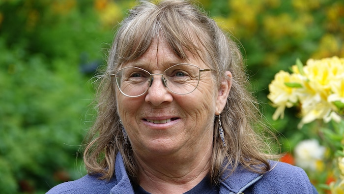 Portrait de Patricia Gallant, devant un arrière-plan fleuri.