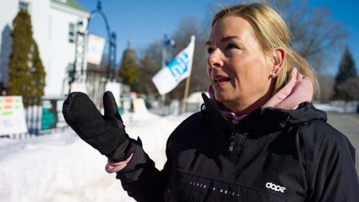 Patricia Mailhot l'hiver devant un drapeau de la FIQ