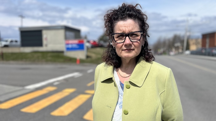 Patricia Pouliot pose sur le terrain de l'Hôtel-Dieu de Lévis. Son regard fixe l'objectif.