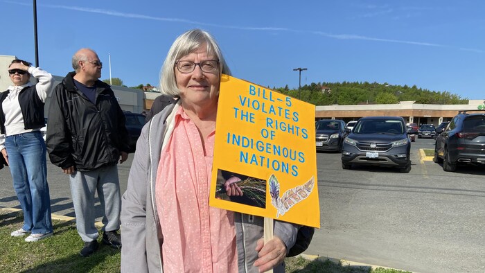 Patricia Rogerson avec une pancarte qui indique que la loi 5 affecte les droits des Premières Nations.