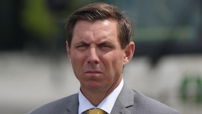Patrick Brown regarde vers la caméra à distance lors d'un point de presse à l'extérieur.