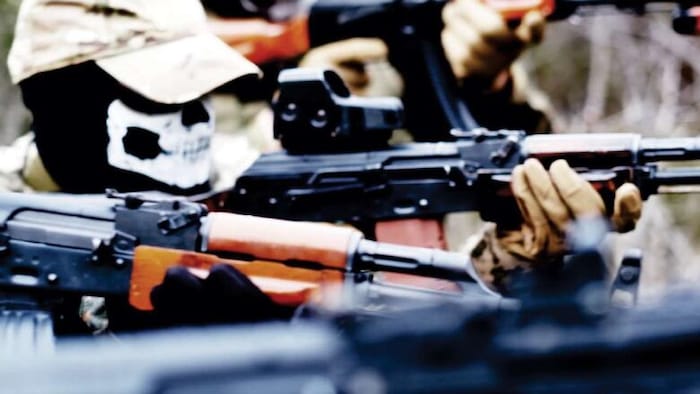 Des personnes masquées tenant des armes à feu.