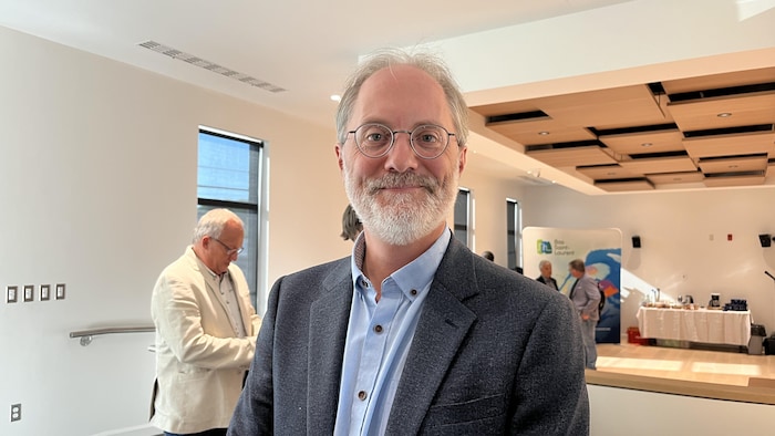Patrick Morin dans une salle remplit d'élus qui discutent en petits groupes.
