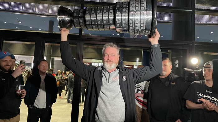 Patrick Roy tenant un trophée.