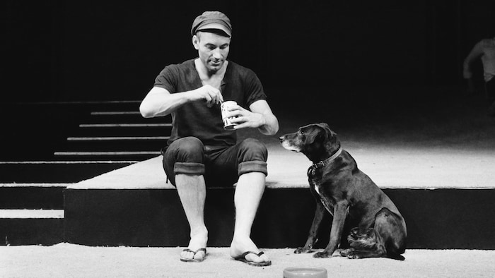 Un homme est sur scène avec un chien.