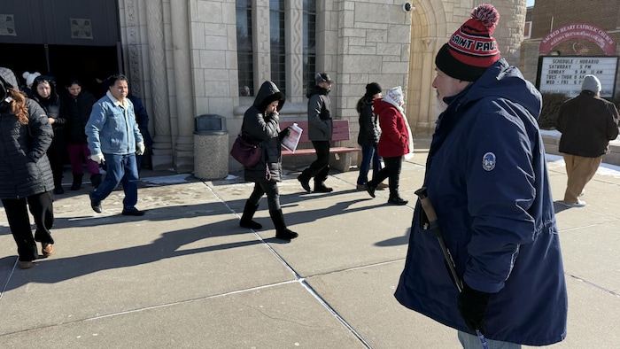 Un homme se tenant sur le parvis de l'église Sacred Heart de Saint Paul. 