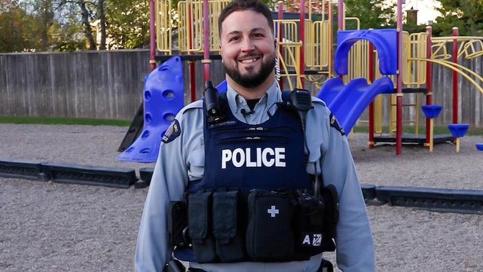 Un policier devant un terrain de jeu.