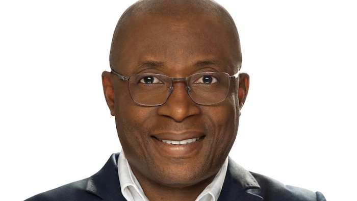 Paul Dadie souriant sur un fond blanc.