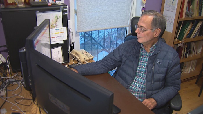 Un homme travaille assis à l'ordinateur.