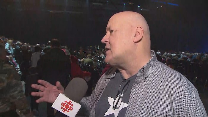 Paul Marcel Albert dans une salle pleine de spectateurs.