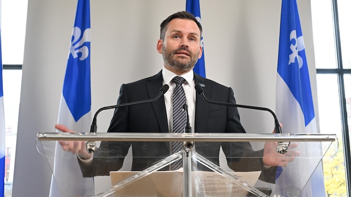 Il s'adresse aux médias lors d'un point de presse.