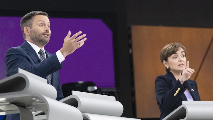 Paul St-Pierre Plamondon et Christine Fréchette font des gestes de la main derrière leurs pupitres