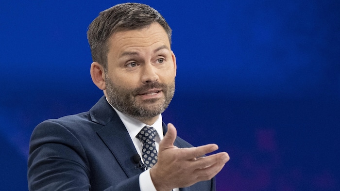 Paul St-Pierre Plamondon fait un geste de la main en s'exprimant derrière son pupitre.