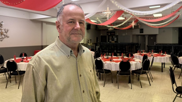 Serge Gervais pose pour la caméra dans une salle de réception.