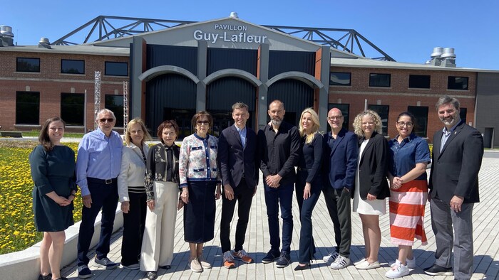 Le maire Marchand, Lise Lafleur, Martin Lafleur et des représentants de la ville de Québec et d'ExpoCité prennent la pose devant le pavillon Guy Lafleur. 