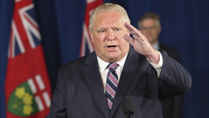 Doug Ford fait un grand geste lors d'une conférence de presse.