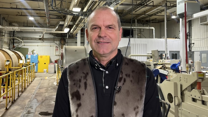 Un homme pose dans une usine.