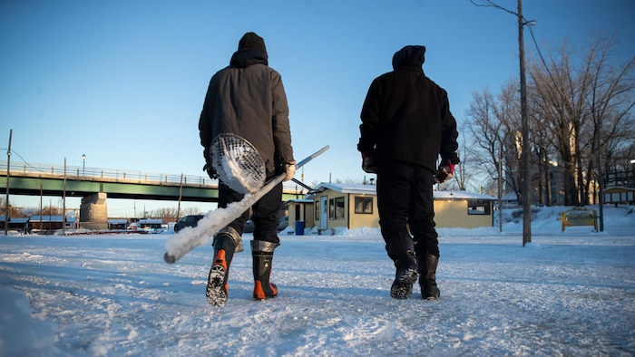 Des gens qui marchent vers les cabanes de pêche