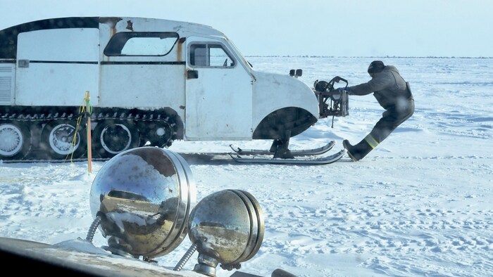 Un pêcheur tite une autoneige