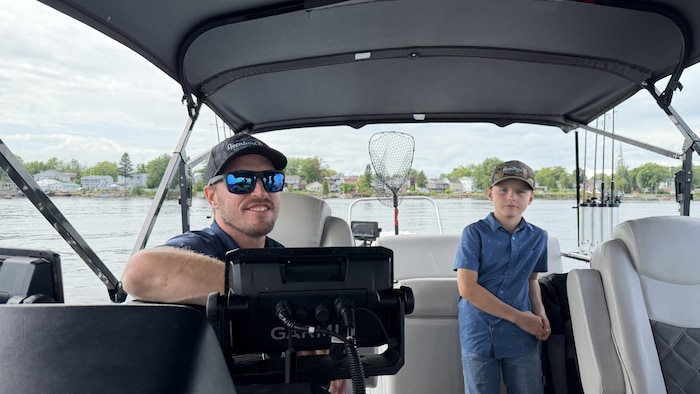 Un homme et un enfant sur un bateau de pêche. 