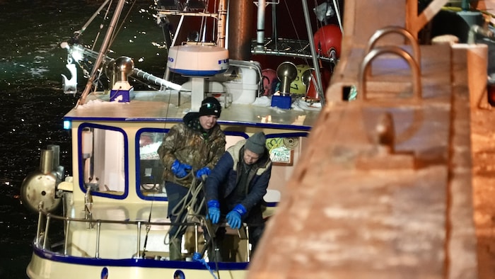 Deux personnes qui travaillent sur un bateau.