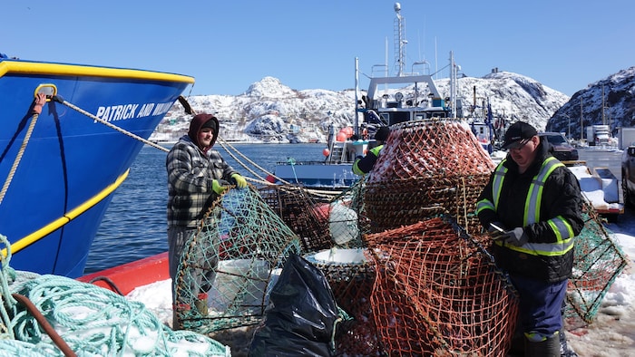 Des crabiers réparent leurs casiers sur le quai de Saint-Jean, à Terre-Neuve-et-Labrador, le 2 avril 2026.