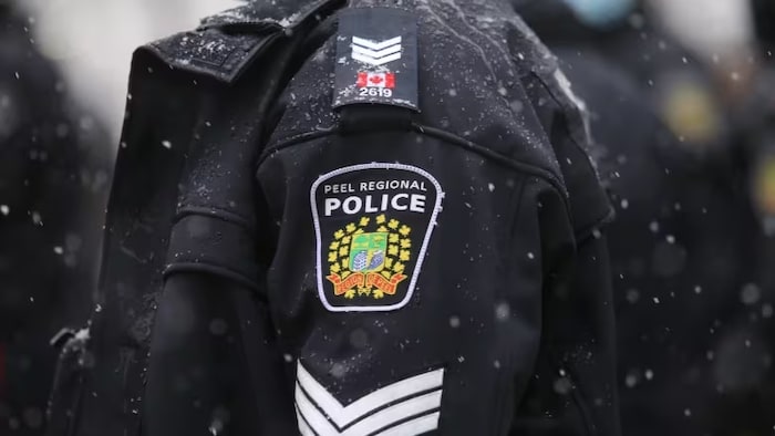 Une image rapprochée de l'écussion du corps policier sur la manche d'un agent.