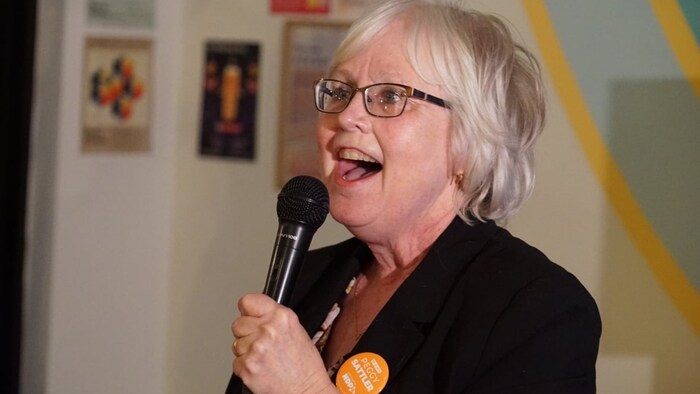 Peggy Sattler tient un micro dans ses mains