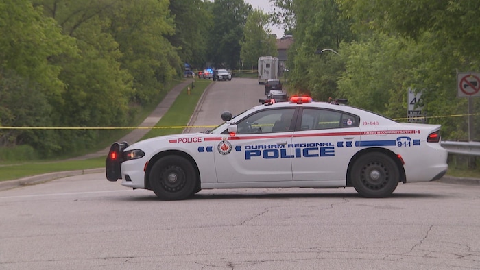 Une voiture de police devant une scène de crime.