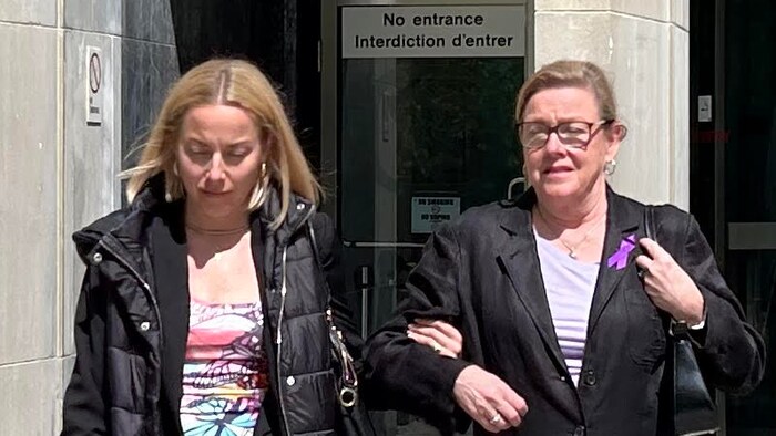 Une femme et sa mère sortent d'un tribunal.