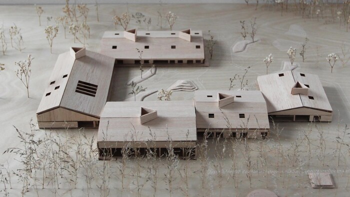 Une maquette présentant cinq bâtiments entourés d'arbres.