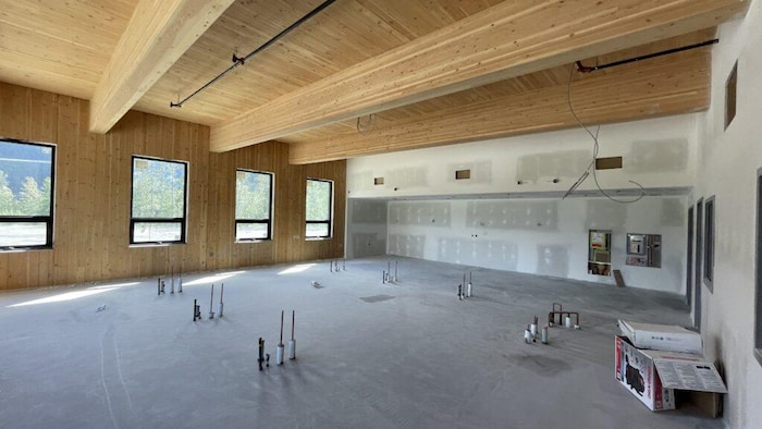 Une salle avec un plancher en béton et un plafond en bois.